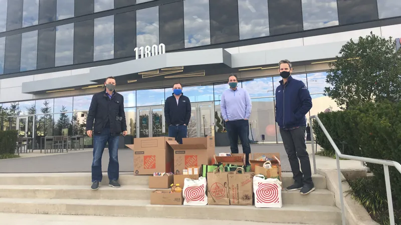 4 men standing in front of an office building.