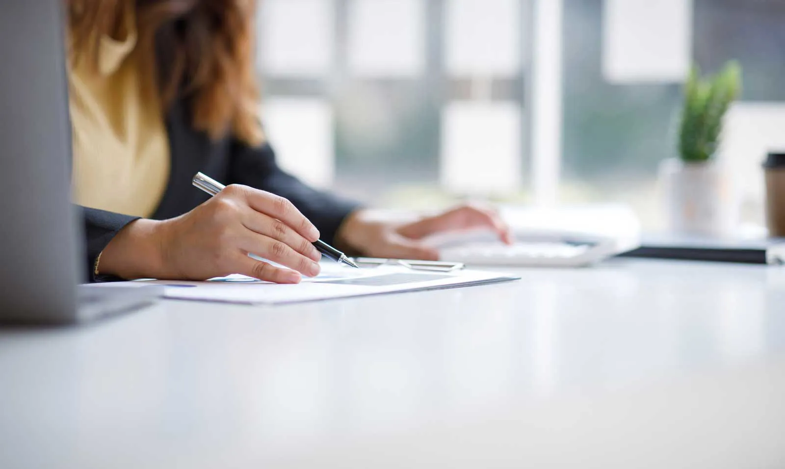 Woman's hands working at a desk.