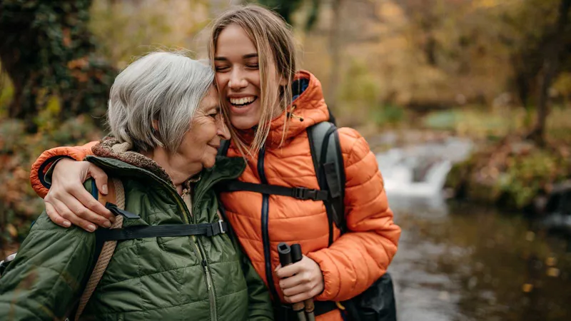 Women hiking near a stream.